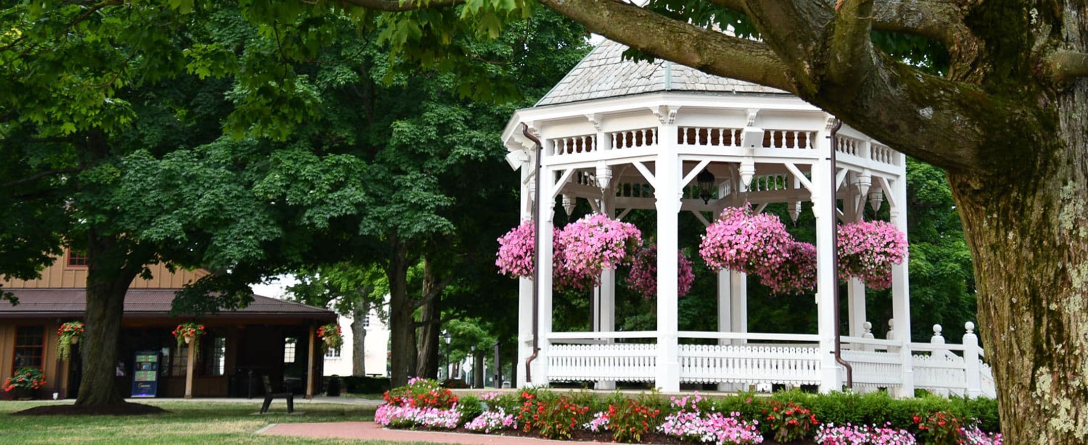 A flower-lined gazebo in a leafy community park